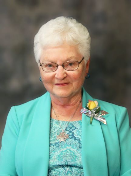 woman-turquoise-suit-white-hair-glasses-corsage