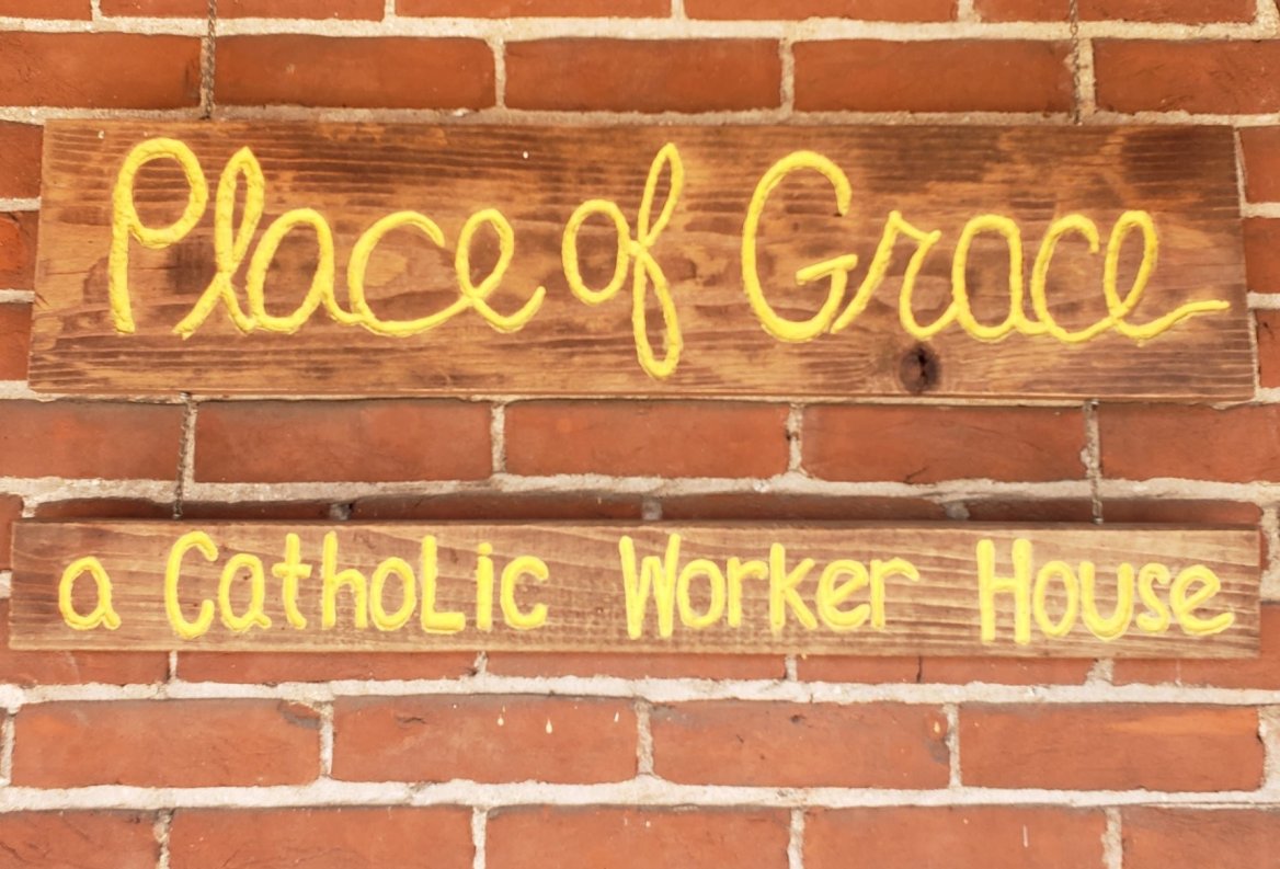 Place of Grace a Catholic Worker House signage on a brick building