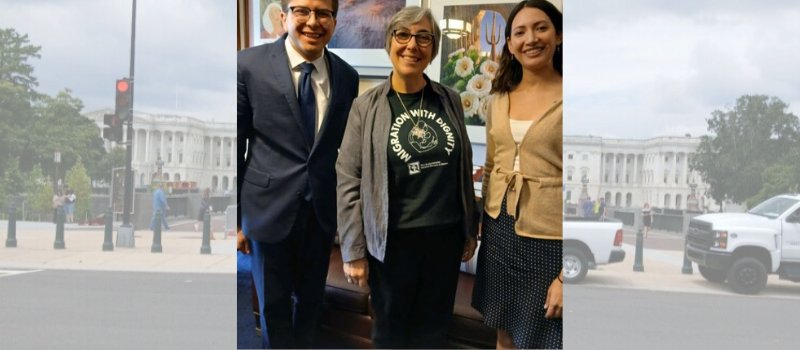 man in dark hair, glasses, navy blue suit and tie and woman with gray hair and sweater, black glasses and t-shirt and silver medal and women with long dark hair, black skirt and tan sweater