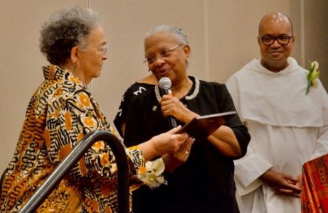 Sr. Eva Marie Lumas, a Sister of Social Service, (left) accepts the National Black Sisters Conference's Harriet Tubman Award from National Black Sisters' Conference President Sr. Addie Lorraine Walker, in Louisville. Looking on is Fr. Jeffery Ott