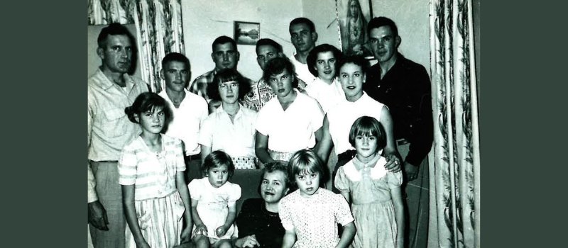 mom and dad pose with their 14 children in this black and white family photo