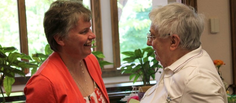 Sister Laurie Sullivan and Sister Luanne Durst smile at one another in conversation